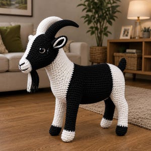 May include: A handcrafted crochet goat toy featuring a black and white colour pattern. The goat has large dark eyes, curved black horns, and a small beard made of yarn. Its body is constructed with visible stitches, showcasing a standing posture.