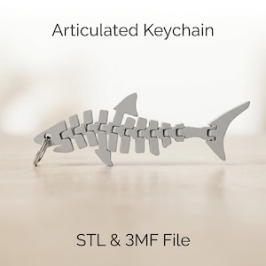 May include: A light gray articulated keychain shaped like a fish skeleton with a metal ring attached to the head. The text Articulated Keychain and STL & 3MF File are printed above and below the object in a clean, sans-serif font.