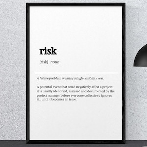 May include: A rectangular black-framed wall art print featuring a dictionary-style definition of the word risk. The text reads: risk [risk] noun. A future problem wearing a high-visibility vest. A potential event that could negatively affect a project.