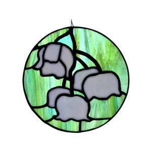 May include: A stained glass window depicting a cluster of white lily of the valley flowers with green leaves. The flowers are outlined in black and the background is a swirling green and blue.