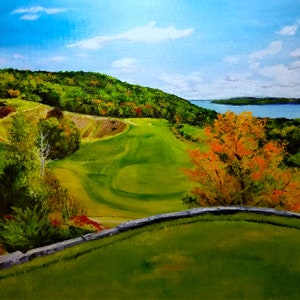 May include: A scenic painting of a golf course with a lake in the background. The course is green and rolling, with trees lining the edges. The lake is blue and calm, with a few clouds in the sky. The painting is done in a realistic style, with vibrant colors.