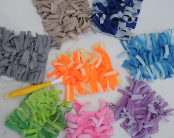 May include: A yellow and white handled duster with a bright orange fabric head, surrounded by seven additional square fabric duster heads in beige, dark blue, light blue, grey, green, pink, and purple, all featuring long, thin fabric strips.