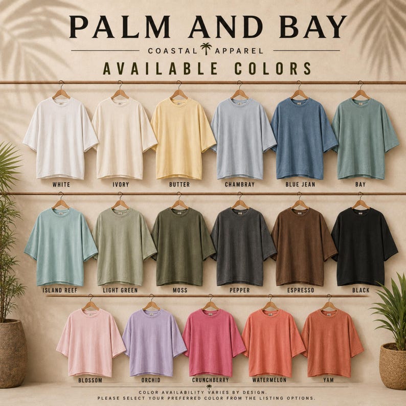 May include: A collection of short-sleeved t-shirts displayed on hangers in seventeen distinct colours, including white, ivory, butter, chambray, blue jean, bay, island reef, light green, moss, pepper, espresso, black, blossom, orchid, crunchberry, watermelon, and yam.
