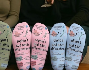 Puede incluir: Cuatro pares de calcetines personalizados en blanco, verde salvia, rosa claro y azul claro, cada uno con el texto 'Bad Bitch Affirmations' junto con nombres, detalles florales y varias frases motivacionales impresas en la tela.