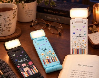 Puede incluir: Tres luces LED rectangulares y plegables para libros con cabezales iluminados. Una es negra con el nombre Isabella, una azul claro con el nombre Sophia y una blanca con el nombre Julia. Cada una presenta gráficos de flores y libros.