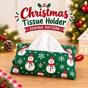 Peut inclure: Un porte-mouchoirs rectangulaire en tissu avec un fond vert orné d'un motif répétitif de flocons de neige blancs et de bonhommes de neige portant des bonnets et écharpes rouges. Il possède une languette rouge et le texte Christmas Tissue Holder SEWING PATTERN.