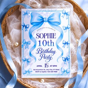 May include: A rectangular birthday party invitation card featuring a large watercolor-style blue bow at the top and smaller blue bows along the border. The text reads: PLEASE JOIN US CELEBRATE SOPHIE 10th Birthday Party APRIL 15 AT 6PM.
