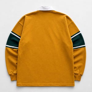 May include: A long-sleeve rugby shirt in mustard yellow featuring a white collar and horizontal dark green bands on the sleeves, accented by thin white stripes bordering the green sections, with ribbed cuffs and a straight hemline.