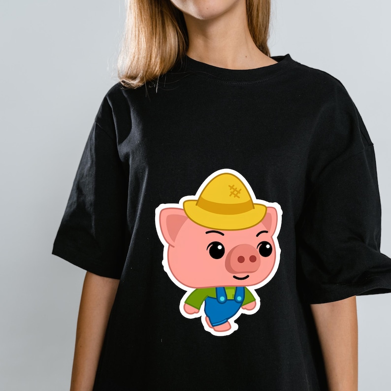 May include: A black short-sleeved t-shirt featuring a graphic of a cartoon pig wearing a yellow straw hat, a green shirt, and blue overalls. The pig has large black eyes, a pink snout, and a simple black line for a mouth, centered on the chest.