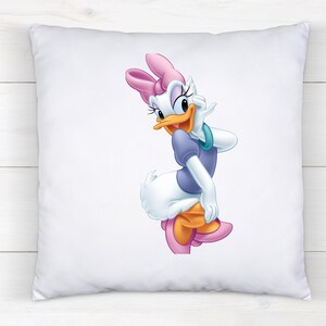 May include: A square white throw pillow featuring a centered, full-color graphic illustration of Daisy Duck. The character is depicted with a pink bow, a purple shirt, and teal bracelets, standing in a pose with one hand raised to her cheek.