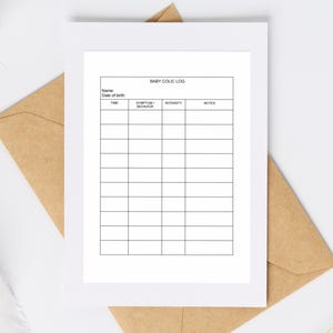 May include: A white rectangular paper sheet featuring a printed black grid titled BABY COLIC LOG. The form includes fields for Name and Date of birth, followed by columns labeled TIME, SYMPTOM/BEHAVIOR, INTENSITY, and NOTES, resting on a brown envelope.