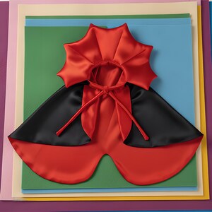May include: A reversible cape featuring a vibrant red satin side and a solid black satin side. The garment includes a high, star-shaped collar and long fabric ties at the neck for closure. The design is symmetrical with a smooth, glossy finish.
