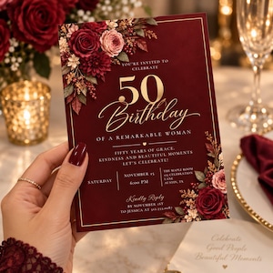 May include: A rectangular 50th birthday invitation card in deep burgundy with gold text and floral accents. The text reads: You're invited to celebrate 50 Birthday of a remarkable woman. Fifty years of grace, kindness and beautiful moments. Let's celebrate!