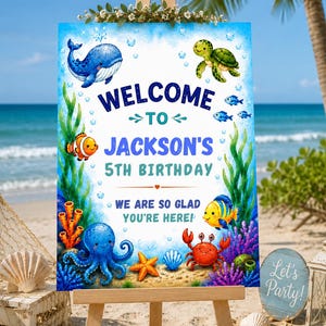 Puede incluir: Un cartel rectangular de bienvenida de cumpleaños con temática submarina que muestra una ballena azul, una tortuga marina verde, un pez payaso naranja, un pulpo azul, un cangrejo rojo y un pez amarillo. El texto dice Welcome to Jackson's 5th Birthday.