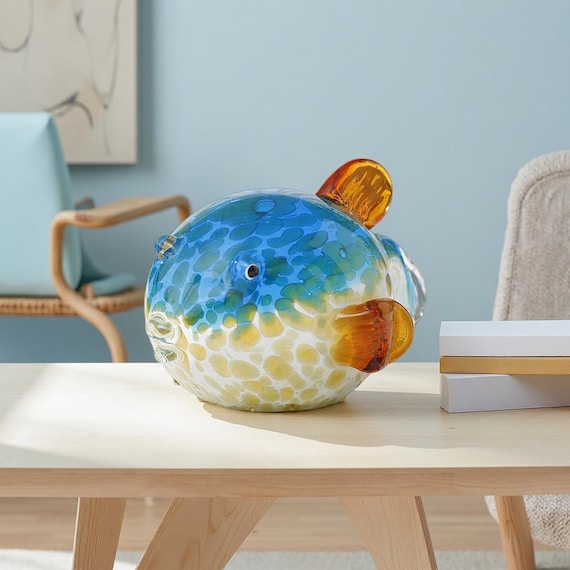 A lampwork pufferfish so detailed and chubby it looks like it swam straight off a reef — the kind of handmade glass sculpture that stops guests mid-sentence.