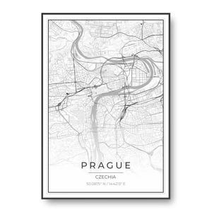 May include: A framed map print of Prague, Czechia, featuring a detailed black and white street grid and river layout. The text PRAGUE, CZECHIA, and the coordinates 50.0875° N / 14.4213° E are printed in a clean, sans-serif font at the bottom.