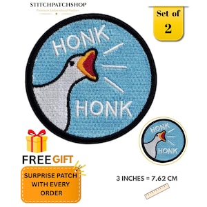May include: A circular embroidered patch featuring a white goose with an orange beak on a light blue background. The text HONK appears above and below the goose, with white lines indicating sound. The patch measures 7.62 cm or 3 inches.