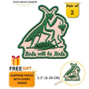 May include: An embroidered patch featuring a green praying mantis on a light pink background with the text "Girls will be Girls" in green thread. The patch measures 8.38 cm in height as indicated by a visible ruler. This is a pair of two patches.