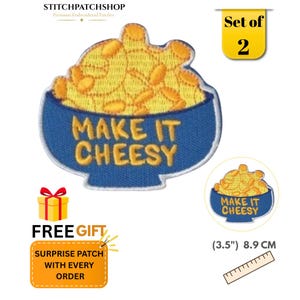 May include: A set of two embroidered patches featuring a blue bowl filled with yellow macaroni and cheese. The text MAKE IT CHEESY is stitched in yellow on the front of the bowl. A ruler shows the patch measures 3.5 inches in width.