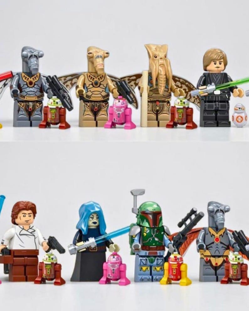May include: A collection of Star Wars themed plastic minifigures including various alien characters, a Jedi in black robes, a bounty hunter in green armor, and several small droid figures in red, pink, and white colors, all standing on a white surface.