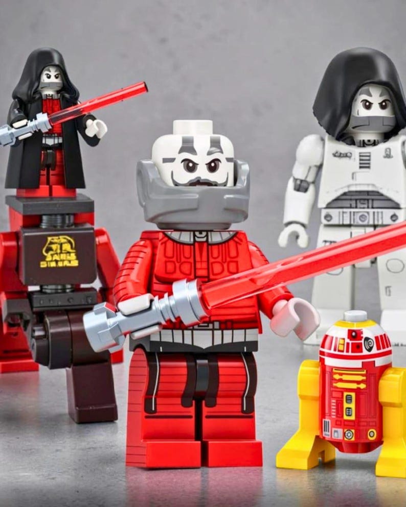 May include: A collection of four plastic building block figures including a character in a red suit with a red lightsaber, a character in a black cloak with a red lightsaber, a white armored character, and a small red and yellow droid figure.