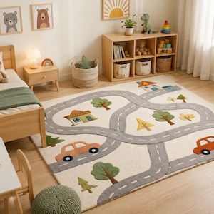 May include: A rectangular area rug featuring a light cream background with a textured gray road pattern, orange cars, green trees, and small houses. The rug is designed with a raised, soft pile and includes various colorful landscape elements.