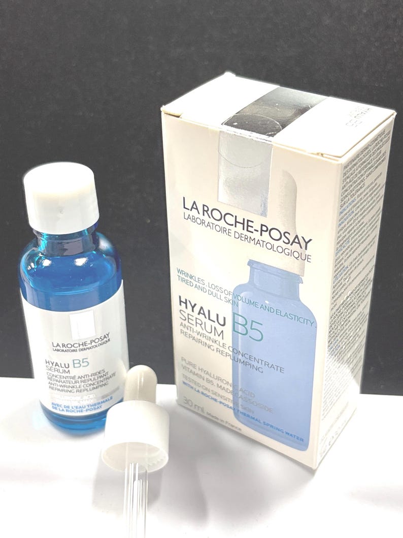 May include: A blue glass bottle of La Roche-Posay Hyalu B5 serum with a white dropper cap and its matching white and blue cardboard box. The packaging features the text La Roche-Posay Laboratoire Dermatologique, Hyalu B5 Serum, and 30 ml.