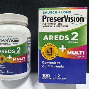 Könnte beinhalten: Eine weiße Kunststoffflasche und eine rechteckige Pappschachtel mit Bausch + Lomb PreserVision AREDS 2 + Multi Vitamin Augenergänzungsmitteln. Beide Behälter zeigen grüne, violette und orangefarbene Akzente, ein gelbes Empfehlungssiegel und 100 Softgels.