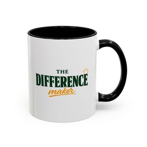 Peut inclure: Un mug en céramique blanche avec un intérieur et une anse noirs. L'avant présente le texte THE DIFFERENCE maker en lettres vert foncé et orange, avec une petite icône de soleil orange au-dessus du mot maker sur le côté droit.