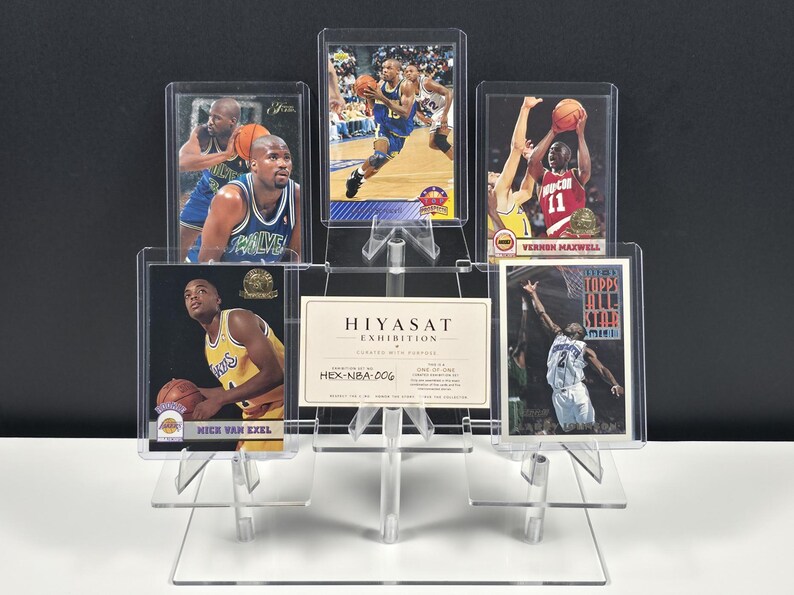 K&ouml;nnte beinhalten: Ein transparenter, mehrstufiger Acryl-Pr&auml;sentationsst&auml;nder mit f&uuml;nf Basketball-Sammelkarten und einer zentralen rechteckigen Karte mit der Aufschrift HIYASAT EXHIBITION HEX-NBA-006. Die Karten zeigen verschiedene Spieler in Aktion, darunter Vernon Maxwell, in Schutzh&uuml;llen.