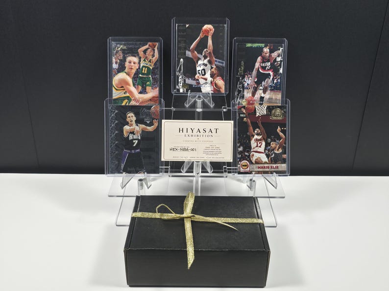 May include: A black gift box with a gold ribbon sits in front of a clear acrylic display stand holding five basketball trading cards and a white card with the text HIYASAT EXHIBITION HEX-NBA-001 printed in black ink.