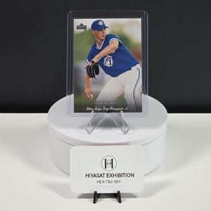 Puede incluir: Una tarjeta de b&eacute;isbol que muestra a Chris Carpenter con un uniforme azul de los Toronto Blue Jays, dentro de una funda de pl&aacute;stico transparente. El texto dice Chris Carpenter y Blue Jays Top Prospect. Un letrero blanco muestra HIYASAT EXHIBITION HEX-TBJ-001.