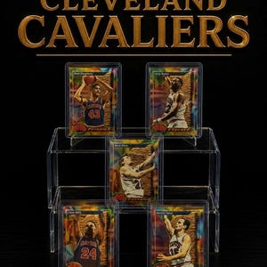 May include: Five Cleveland Cavaliers basketball trading cards in protective plastic cases, arranged on a clear tiered display stand. The cards feature players Brad Daugherty, Larry Nance, Mark Price, Chris Mills, and Derrick Favor with gold foil accents.