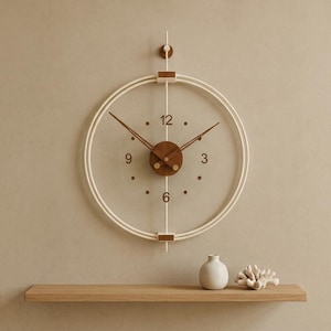 May include: A circular wall clock featuring a white frame and a transparent center. The clock has a dark brown wooden central hub with matching hands and hour markers for 3, 6, 9, and 12. A vertical white rod extends through the center of the clock.