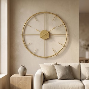 May include: A large, circular wall clock made of thin gold-toned metal. The clock features a minimalist open frame design with straight metal spokes extending from a central circular hub. It has two pointed clock hands and no numbers.