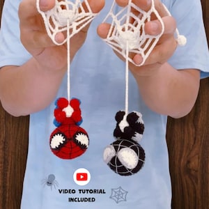 May include: Two handmade crochet ornaments featuring spherical characters with large white eyes, suspended by white yarn from crocheted spider webs. One character is red and blue, the other is black and white. Text reads: VIDEO TUTORIAL INCLUDED.