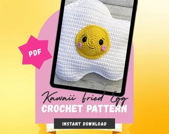May include: A digital tablet displays a crochet pattern for a white and yellow fried egg plush with a smiling face, pink cheeks, and black eyes. The screen features the text Kawaii fried Egg CROCHET PATTERN, PDF, INSTANT DOWNLOAD, BEGINNER FRIENDLY, and COMMERCIAL USE OK.