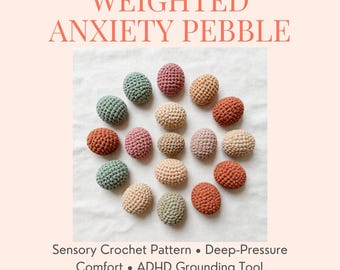 May include: A collection of seventeen small, oval-shaped crochet pebbles arranged in a circular pattern. Each pebble features a textured, knotted surface in various muted earth tones including sage green, dusty rose, terracotta, beige, and cream.