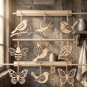 May include: A collection of nine laser-cut wooden ornaments hanging from three horizontal wooden bars. The ornaments feature intricate cut-out designs of birds, butterflies, a bee, and a ladybug, each suspended by a thin twine string.