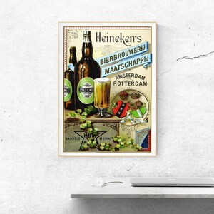 May include: A vintage-style poster featuring two dark glass beer bottles and a glass of golden beer. The text reads Heineken's Bierbrouwerij Maatschappij Amsterdam Rotterdam. It includes a crest with crowns and green ivy vines on a crate.