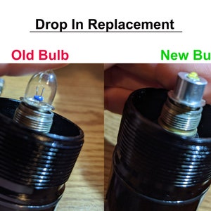 May include: Close-up of an old and new light bulb. The old bulb is a traditional incandescent bulb with a clear glass envelope and a metal filament. The new bulb is a LED bulb with a white plastic housing and a yellow LED chip. "Drop In Replacement" is written above the image. "Old Bulb" is written in red above the old bulb. "New Bulb" is written in green above the new bulb.