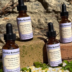 May include: Six amber glass dropper bottles labeled Aloka Botanicals Calming Blend for Anxiety & Panic. Each bottle features a black dropper cap and a white label with black text listing ingredients like Clary Sage, Lavender, and Ylang Ylang.