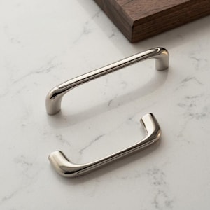 May include: Two polished silver-toned metal cabinet pulls with a smooth, curved arch design. The handles feature a reflective, metallic finish and rounded ends, presented as a pair of hardware components for furniture or cabinetry installation.