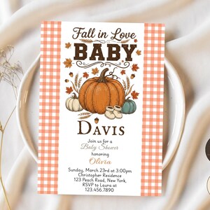 Puede incluir: Una tarjeta de invitación rectangular para baby shower con bordes de cuadros vichy naranjas y blancos. El centro muestra una calabaza naranja grande, una blanca pequeña, una verde azulada, patucos y hojas de otoño. Texto: Fall in Love BABY, Davis, Join us for a Baby Shower honoring Olivia, Sunday, March 23rd at 3:00pm, Christopher Residence, 123 Peach Road, New York, RSVP to Laura at 123.456.7890.