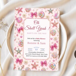 May include: A rectangular baby shower invitation card with a pink background featuring a border of sparkling starfish, seashells, pearls, and pink bows. The text reads Oh Shell Yeah! Baby's on the way, honoring Bonnie & Sam, August 12, 3 PM.