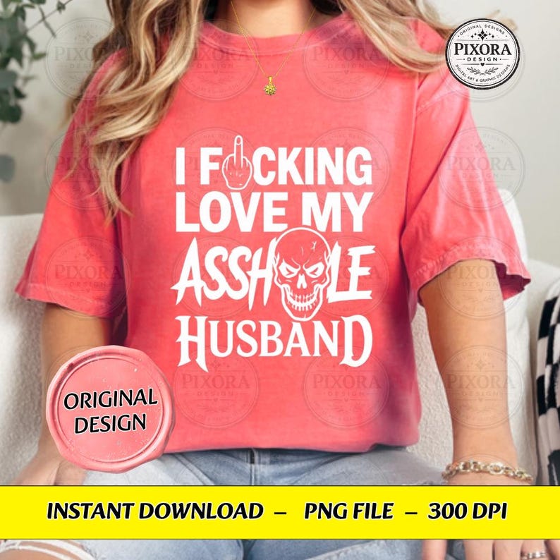 May include: A coral-colored short-sleeve t-shirt featuring white text that reads I FUCKING LOVE MY ASSHOLE HUSBAND, with a graphic of a middle finger replacing the letter U and a skull illustration replacing the letter O in the word ASSHOLE.