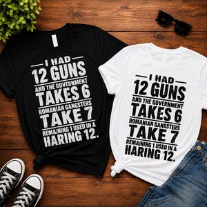 May include: A black t-shirt and a white t-shirt, each featuring the text: I HAD 12 GUNS AND THE GOVERNMENT TAKES 6 ROMANIAN GANGSTERS TAKE 7 REMAINING 1 USED IN A HARING 12. The shirts have short sleeves and a crew neckline with bold black or white lettering.