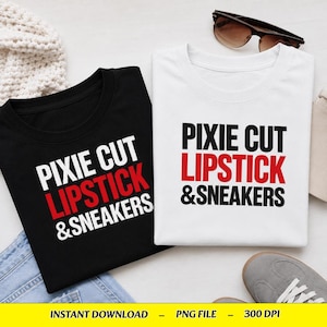 May include: A black t-shirt and a white t-shirt, both featuring the text PIXIE CUT in black, LIPSTICK in red, and &SNEAKERS in black. The shirts are displayed alongside a pair of brown sunglasses and a white knitted fabric piece.