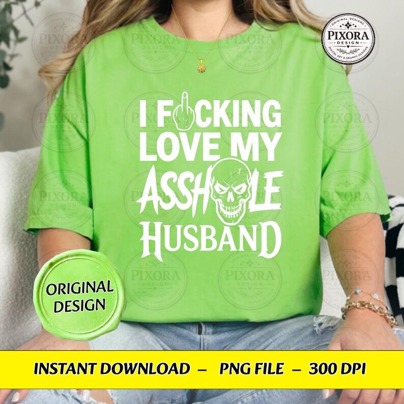 May include: A bright lime green t-shirt featuring white text that reads I FUCKING LOVE MY ASSHOLE HUSBAND, with a middle finger icon replacing the letter U and a skull graphic integrated into the word ASSHOLE. The shirt has short sleeves.