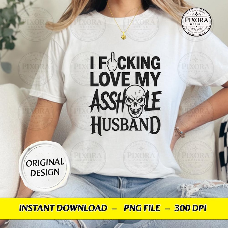 May include: A white short-sleeve t-shirt featuring black text that reads I FUCKING LOVE MY ASSHOLE HUSBAND, with a middle finger icon replacing the letter U and a skull graphic replacing the letter O in the word ASSHOLE.
